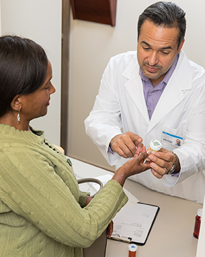 Woman talking to pharmacist at pharmacy counter.